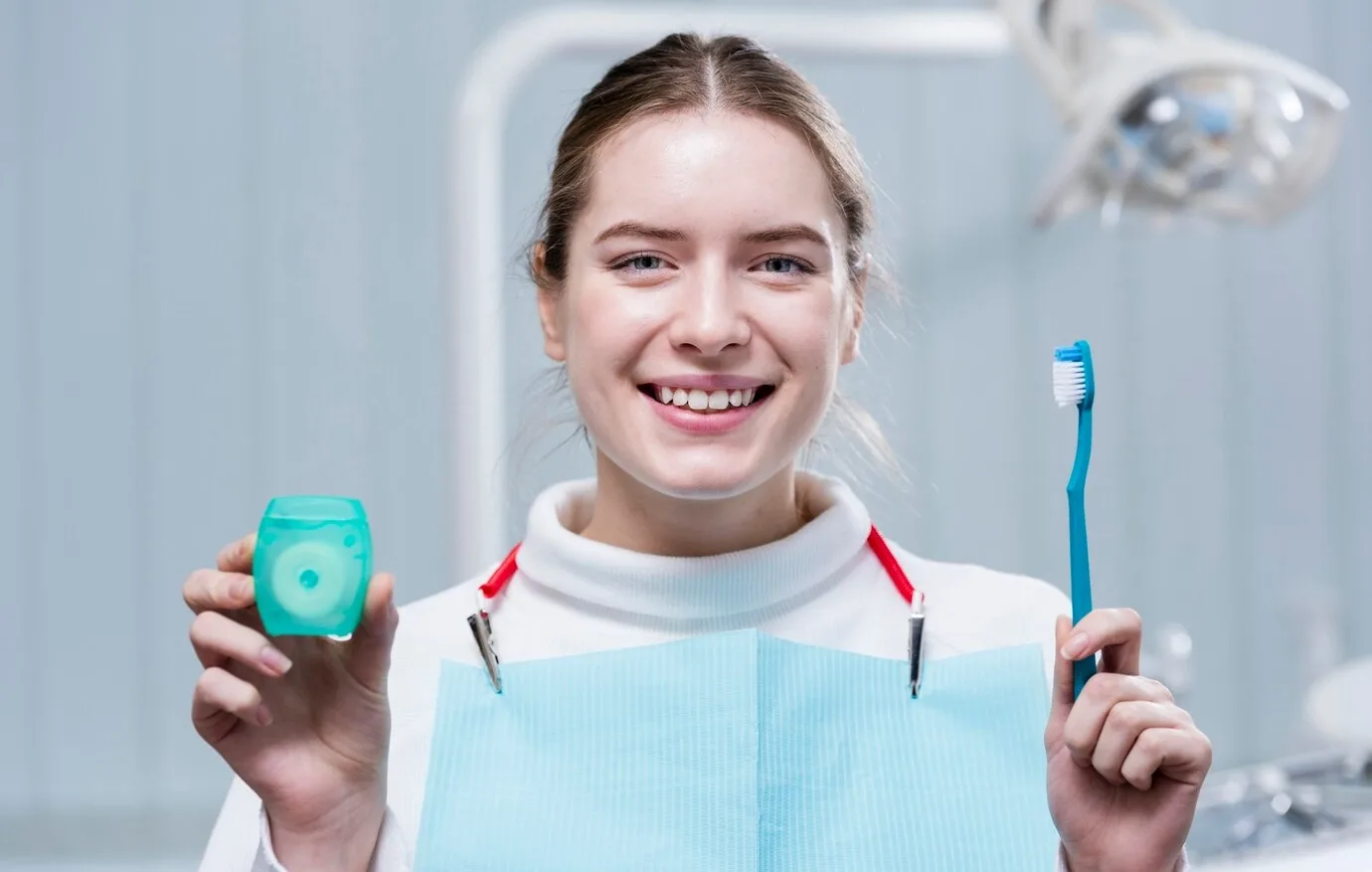 Patient holding a toothbrush and dental floss