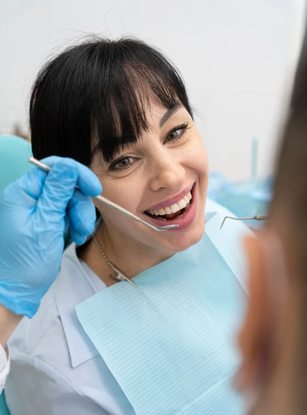 Smiling patient having her teeth examined during a dental check-up