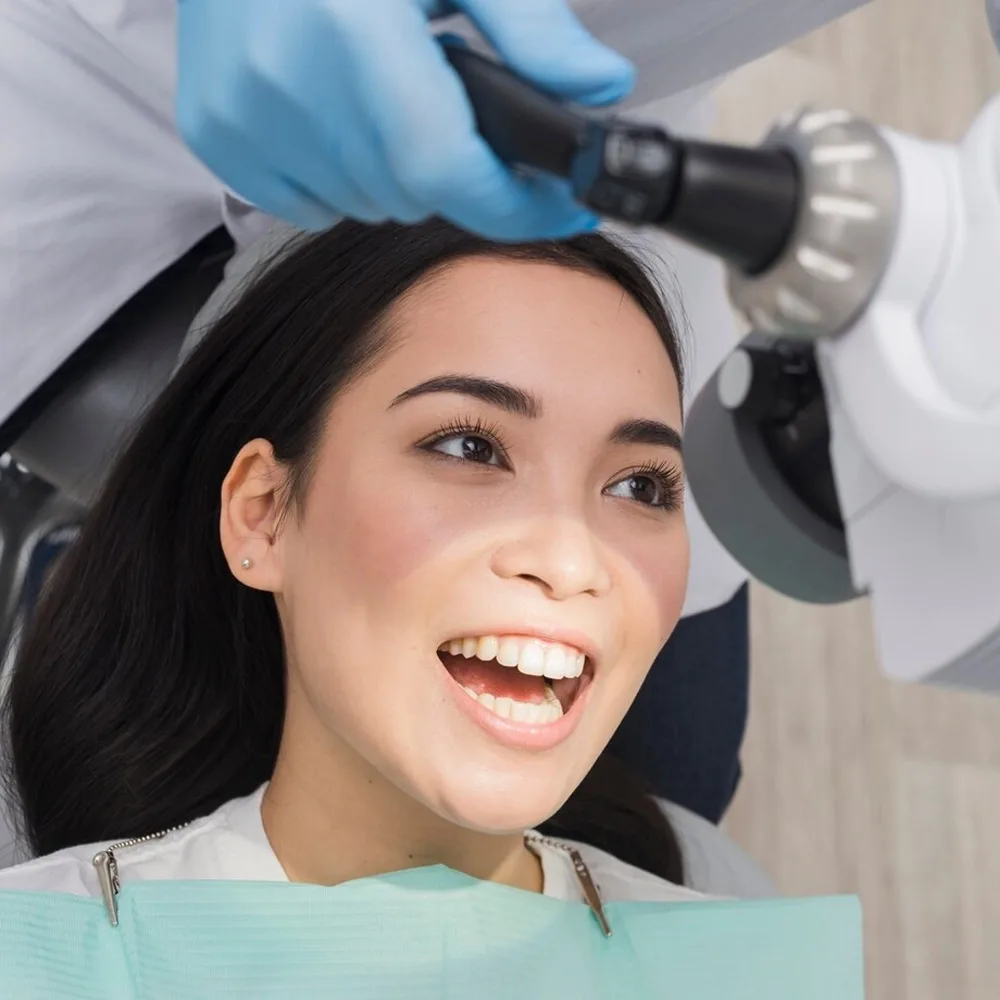 Patient having her teeth examined under a dental microscope
